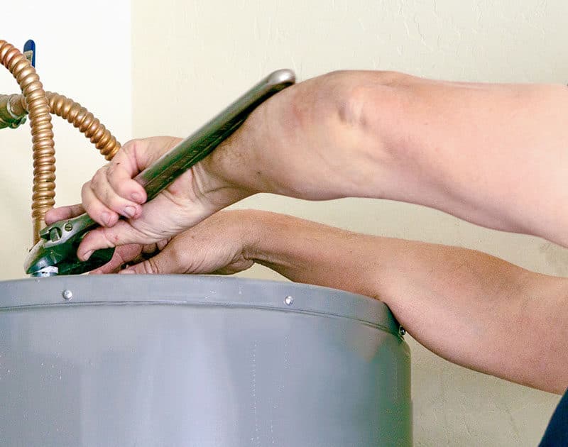 Homeowner performing a water heater repair