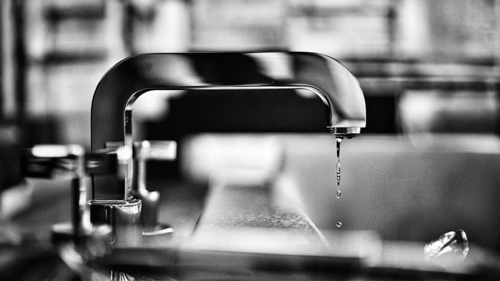 Dripping kitchen faucet illustrating the need for plumbing maintenance