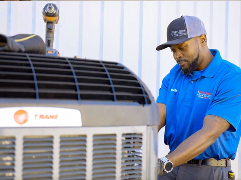 HVAC technician performing air conditioner maintenance