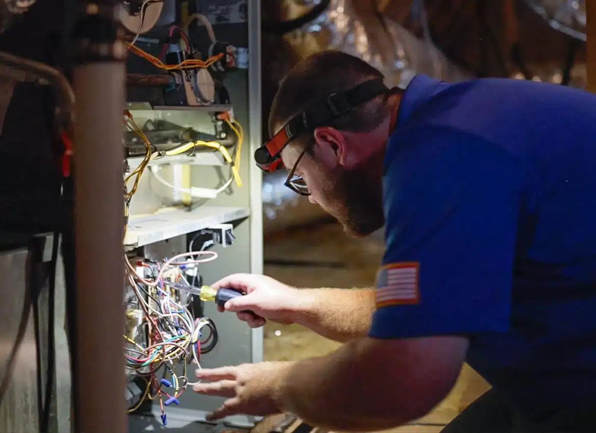 HVAC technician inspecting a residential furnace syste