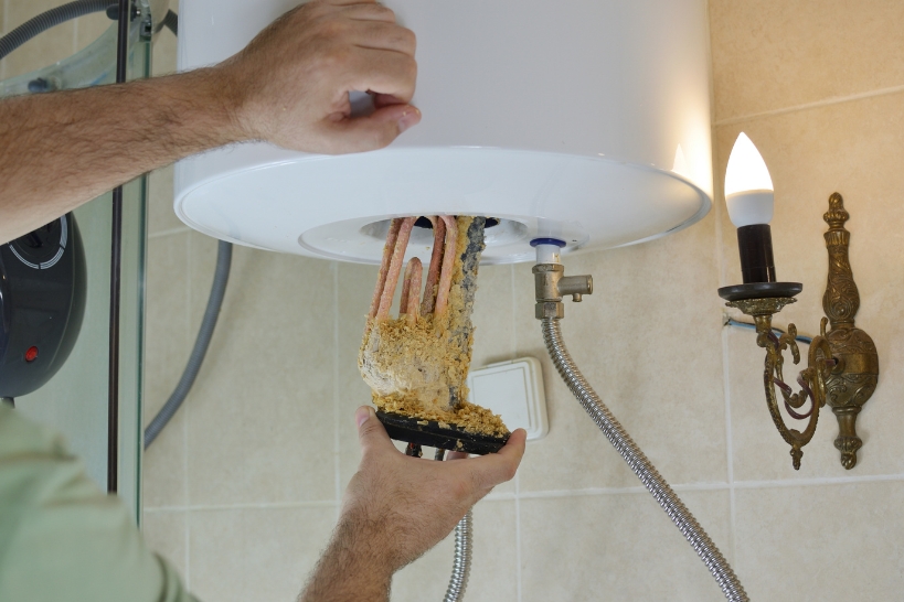 Mineral and sediment buildup on a water heater heating element that can cause rumbling or popping noises.