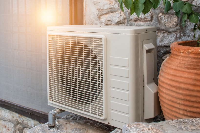 Outdoor heat pump condenser beside a home, representing available heat pump rebates in Orange County.